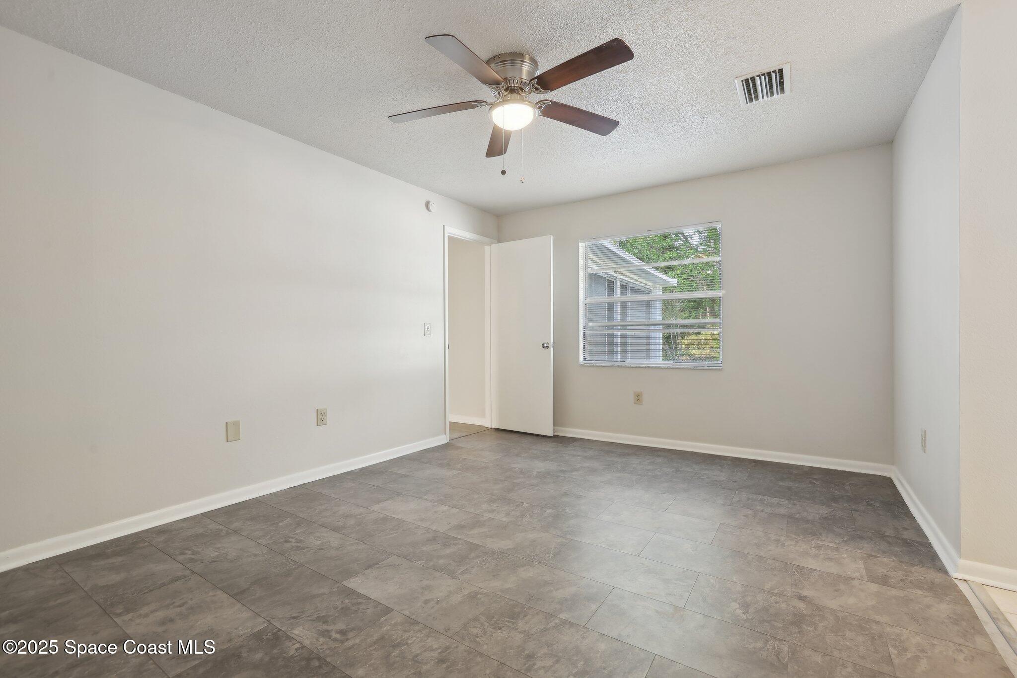 3837 Parapet Drive Cocoa, FL 32926 - Photo 17 of 42 an empty room with windows and ceiling fan