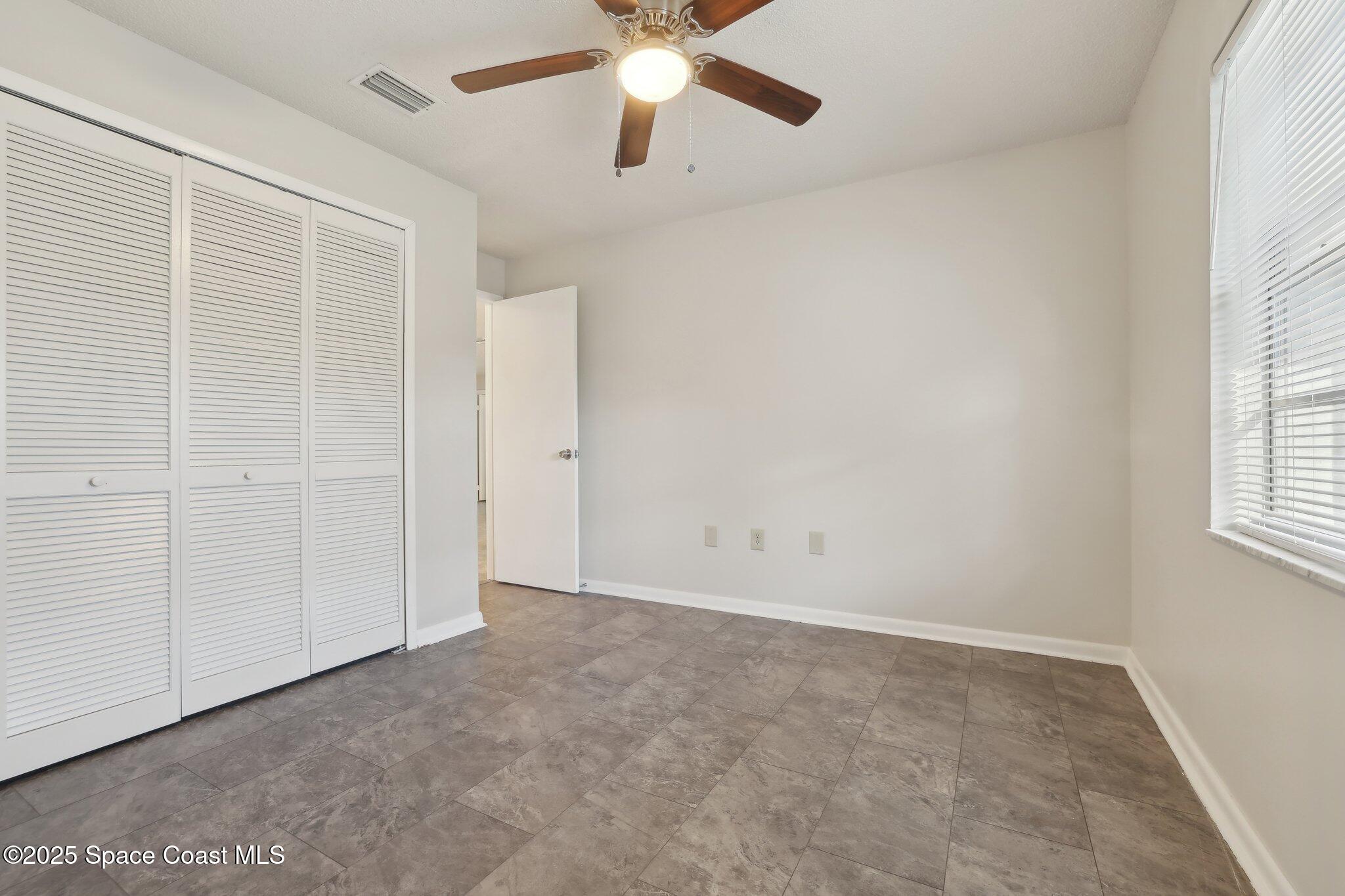 3837 Parapet Drive Cocoa, FL 32926 - Photo 27 of 42 an empty room with windows and fan