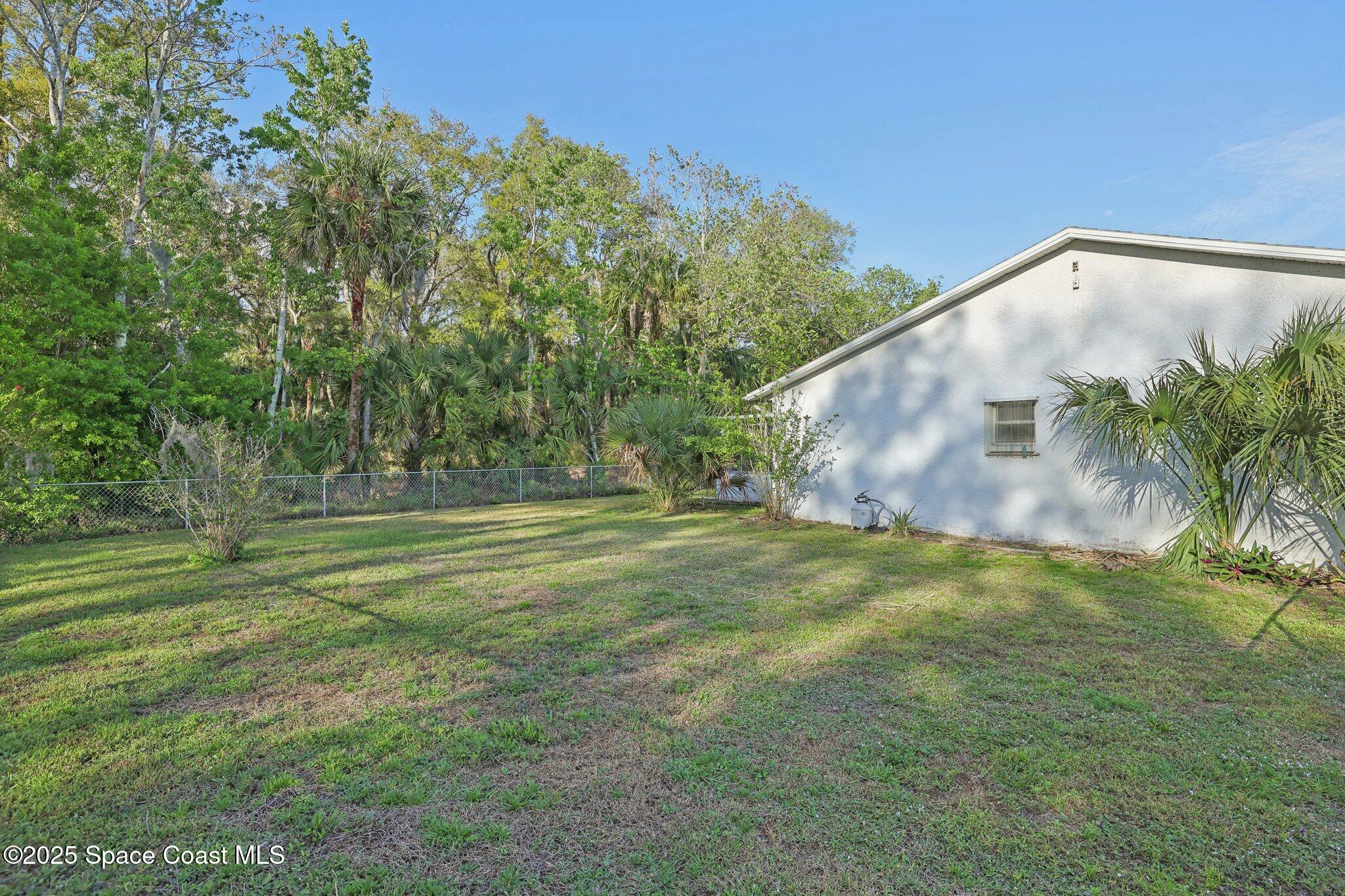 3837 Parapet Drive Cocoa, FL 32926 - Photo 38 of 42 a backyard of a house with lots of green space and fountain