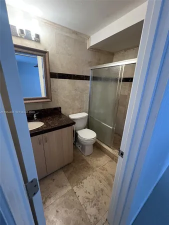 a view of a white house next to a yard with a large tree