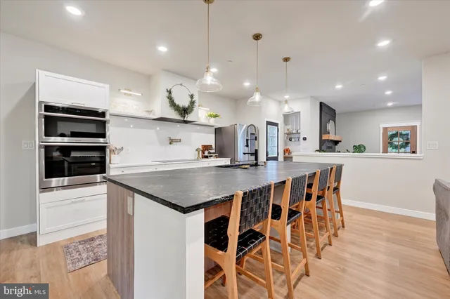 a kitchen with stainless steel appliances kitchen island granite countertop a stove a sink and a refrigerator