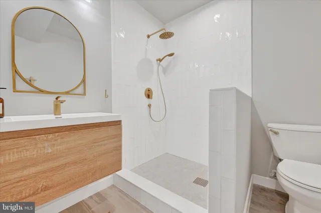 a bathroom with a sink a toilet and a mirror