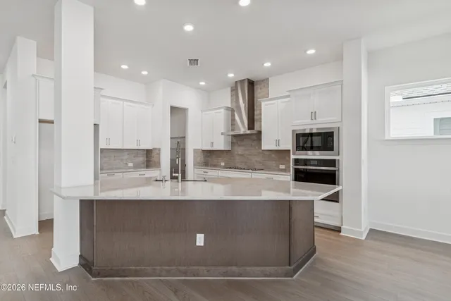 a large kitchen with stainless steel appliances and a refrigerator