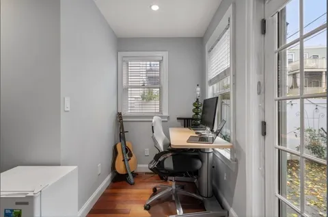 a view of a workspace with furniture and a window