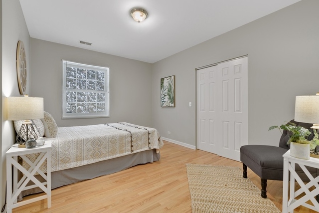 2349 West Harrison Street, Unit 1 Chicago, IL 60612 - Photo 17 of 25 a bedroom with a bed and chair