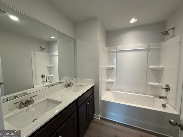 a bathroom with a bath tub sink mirror and a shower