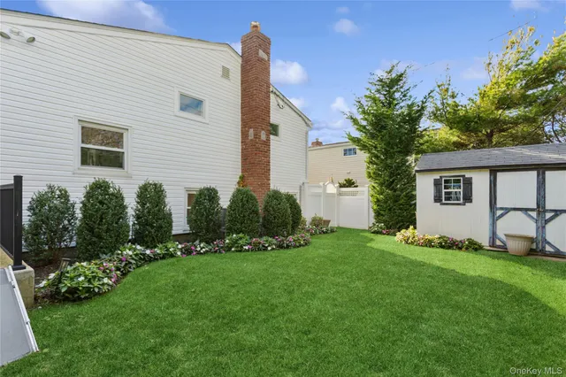 a front view of house with a garden and trees