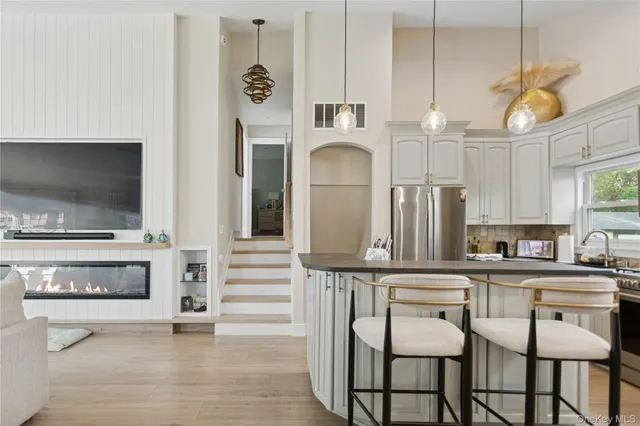 a kitchen with stainless steel appliances a white table chairs and a window