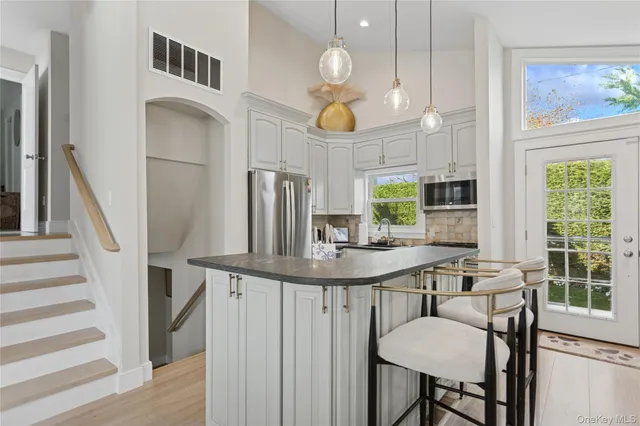 a kitchen with stainless steel appliances granite countertop a stove a sink and a refrigerator