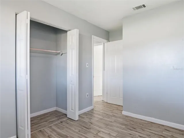 a view of an empty room with a fireplace and a window