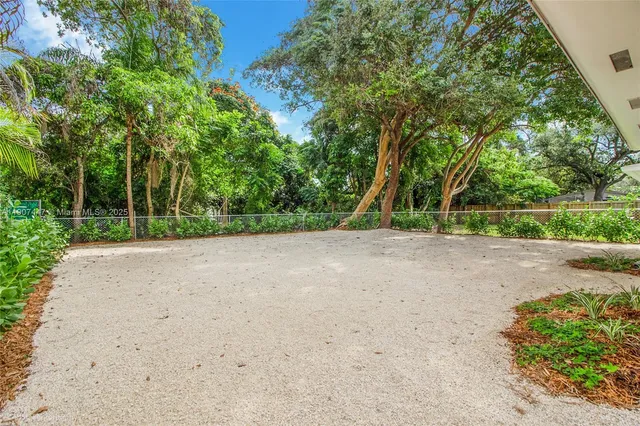 a view of a field with trees in the background