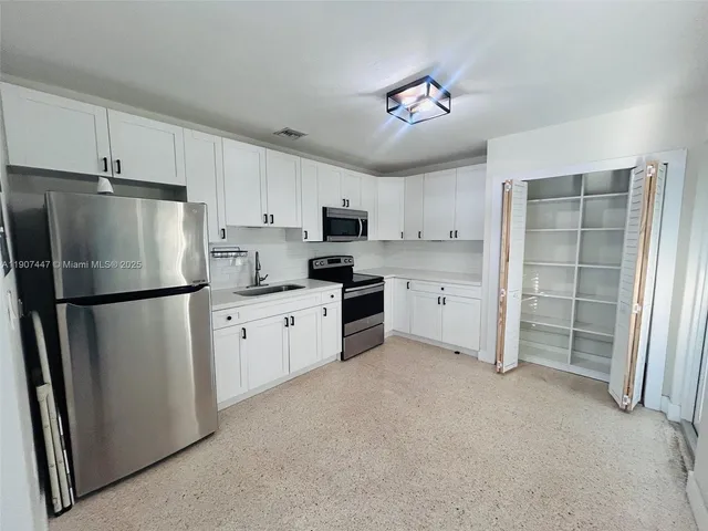 a kitchen with refrigerator a sink and cabinets