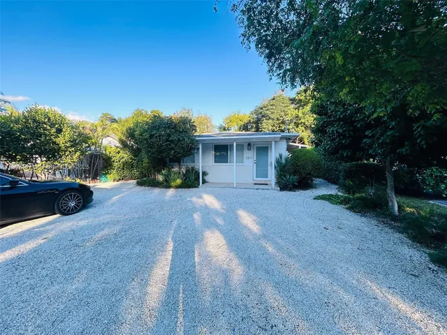 a view of a house with backyard and trees