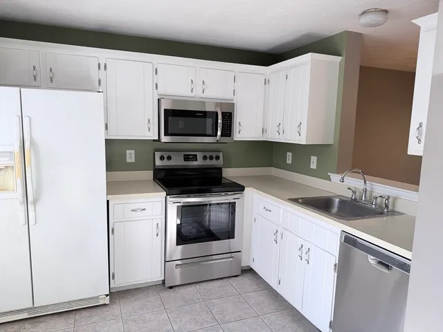 a kitchen with granite countertop white cabinets and white appliances
