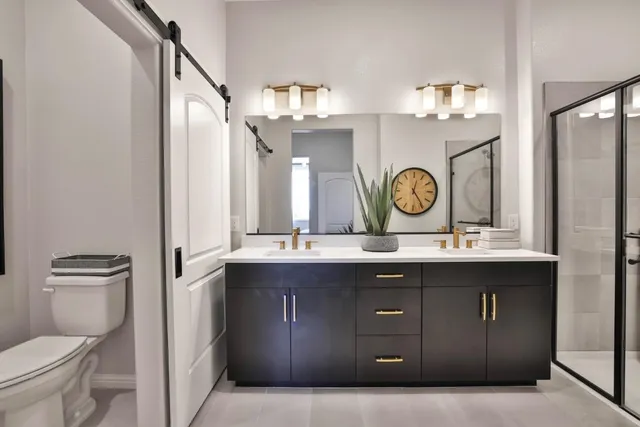 a bathroom with a granite countertop sink a toilet and shower