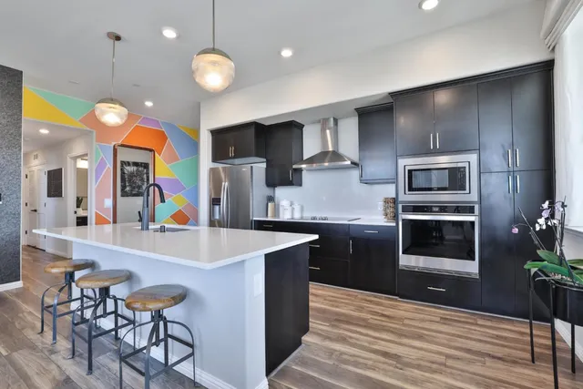a kitchen with counter top space a sink cabinets and stainless steel appliances