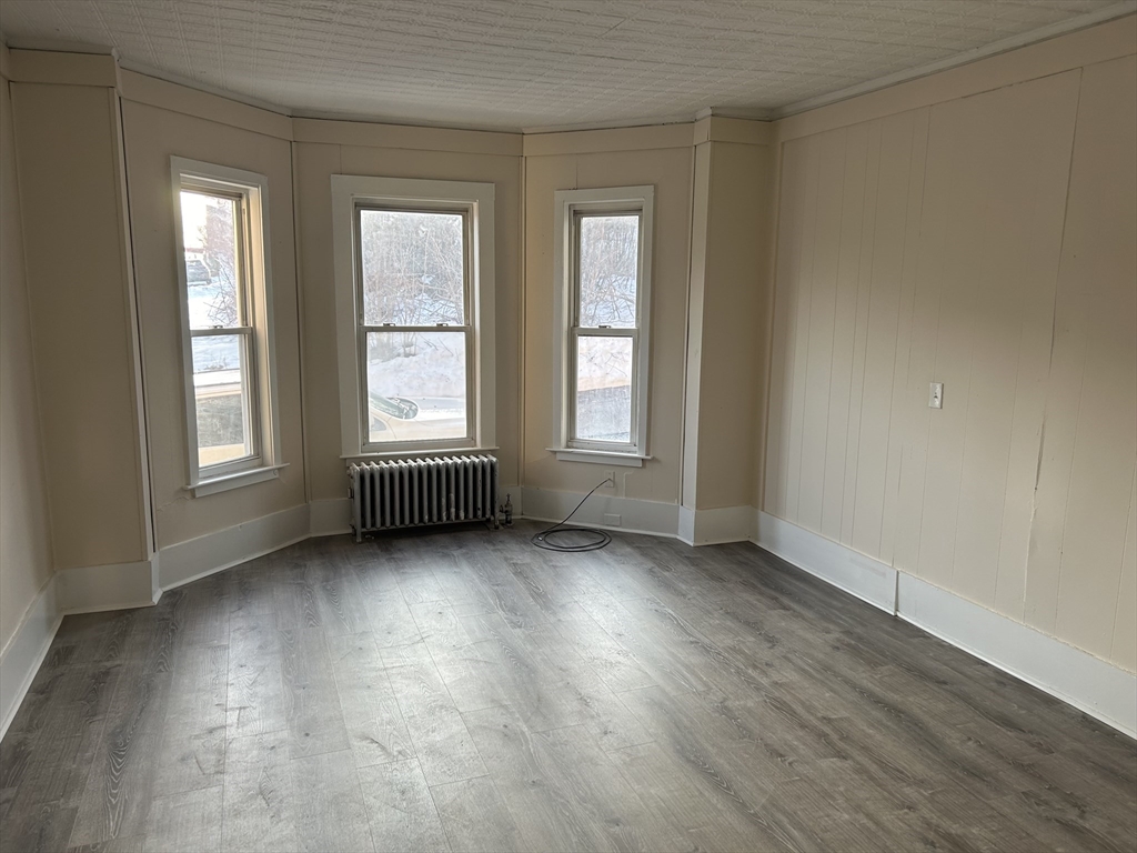 230 Pleasant Street, Unit 1 Worcester, MA 01609 - Photo 1 of 8 an empty room with wooden floor and windows