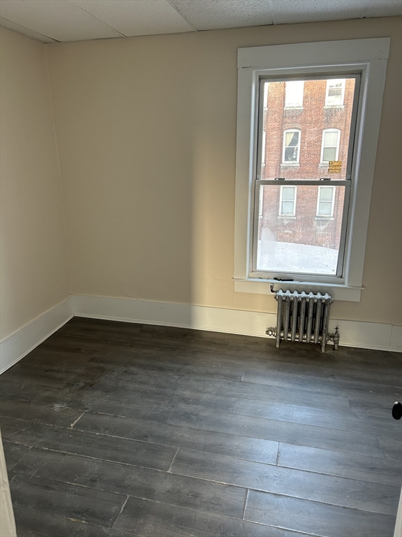 230 Pleasant Street, Unit 1 Worcester, MA 01609 - Photo 3 of 8 an empty room with wooden floor and windows