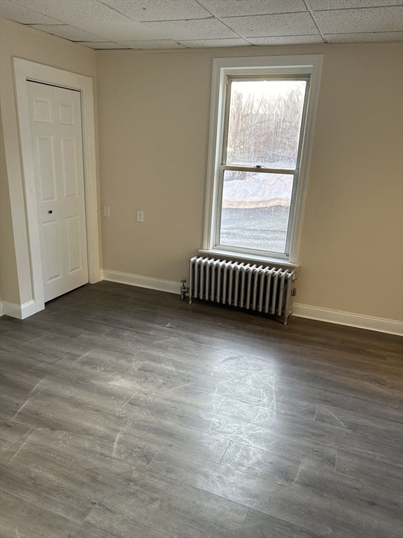230 Pleasant Street, Unit 1 Worcester, MA 01609 - Photo 5 of 8 an empty room with wooden floor and windows