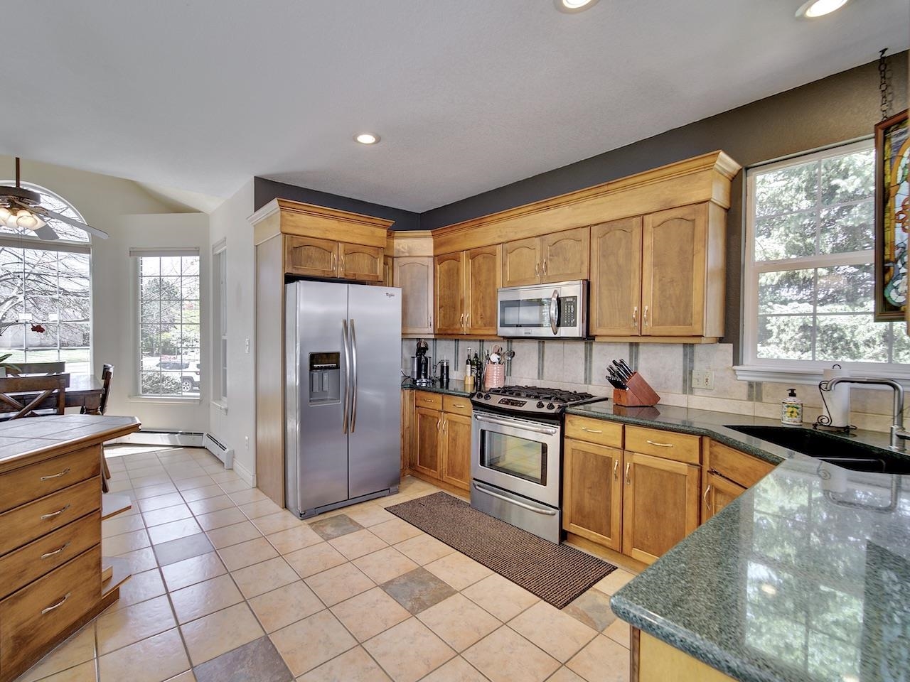 2332 North Falcon Point Court Grand Junction, CO 81507 - Photo 11 of 39 a kitchen with stainless steel appliances granite countertop a stove a sink dishwasher a refrigerator and cabinets with wooden floor