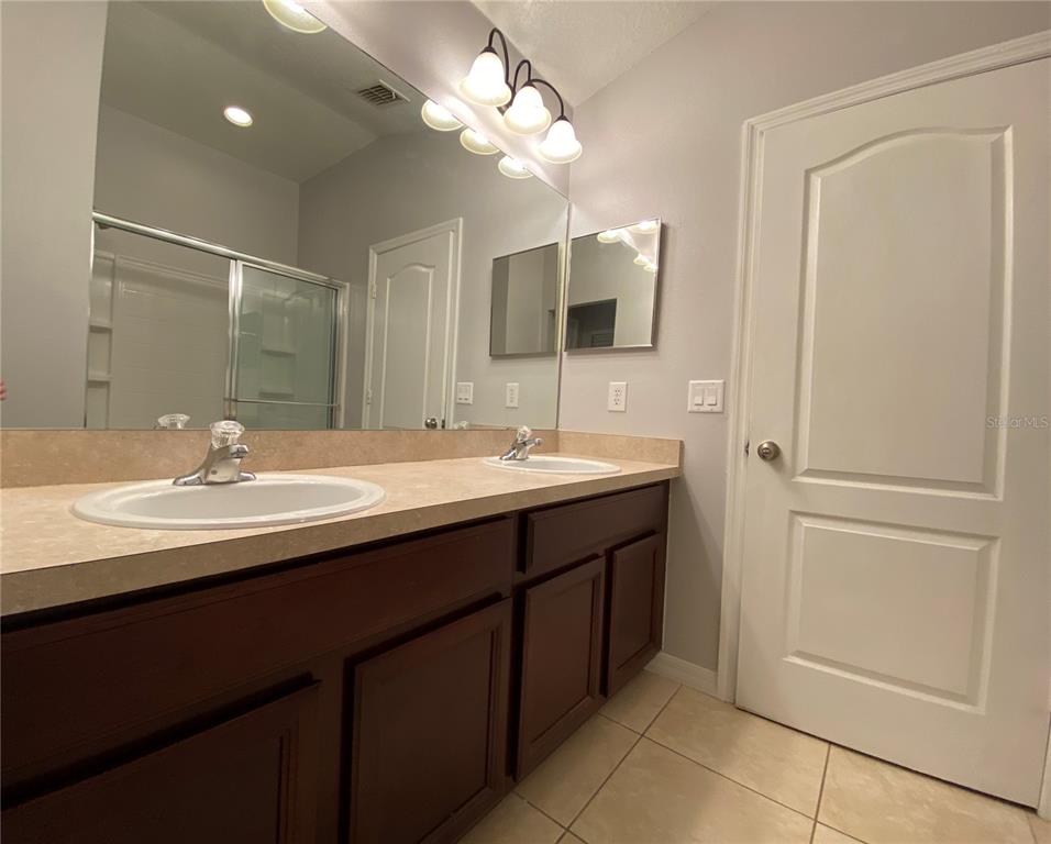 6460 South Goldenrod Road, Unit 30B Orlando, FL 32822 - Photo 11 of 20 a bathroom with a double vanity sink and a mirror