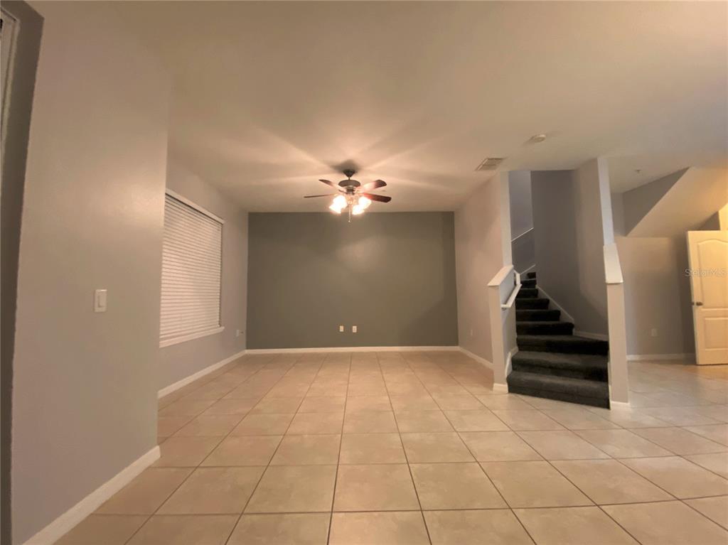 6460 South Goldenrod Road, Unit 30B Orlando, FL 32822 - Photo 4 of 20 a view of an empty room with a windows and ceiling fan