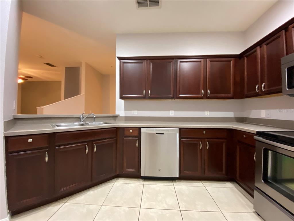 6460 South Goldenrod Road, Unit 30B Orlando, FL 32822 - Photo 7 of 20 a kitchen with stainless steel appliances granite countertop a sink and cabinets