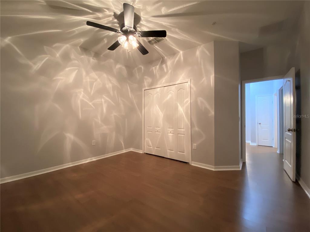 6460 South Goldenrod Road, Unit 30B Orlando, FL 32822 - Photo 9 of 20 a view of an empty room with wooden floor and a fan