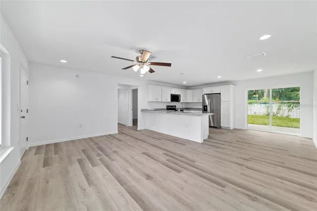 a view of kitchen with wooden floor electronic appliances and window