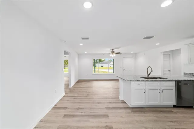 a kitchen with granite countertop a refrigerator stove and sink
