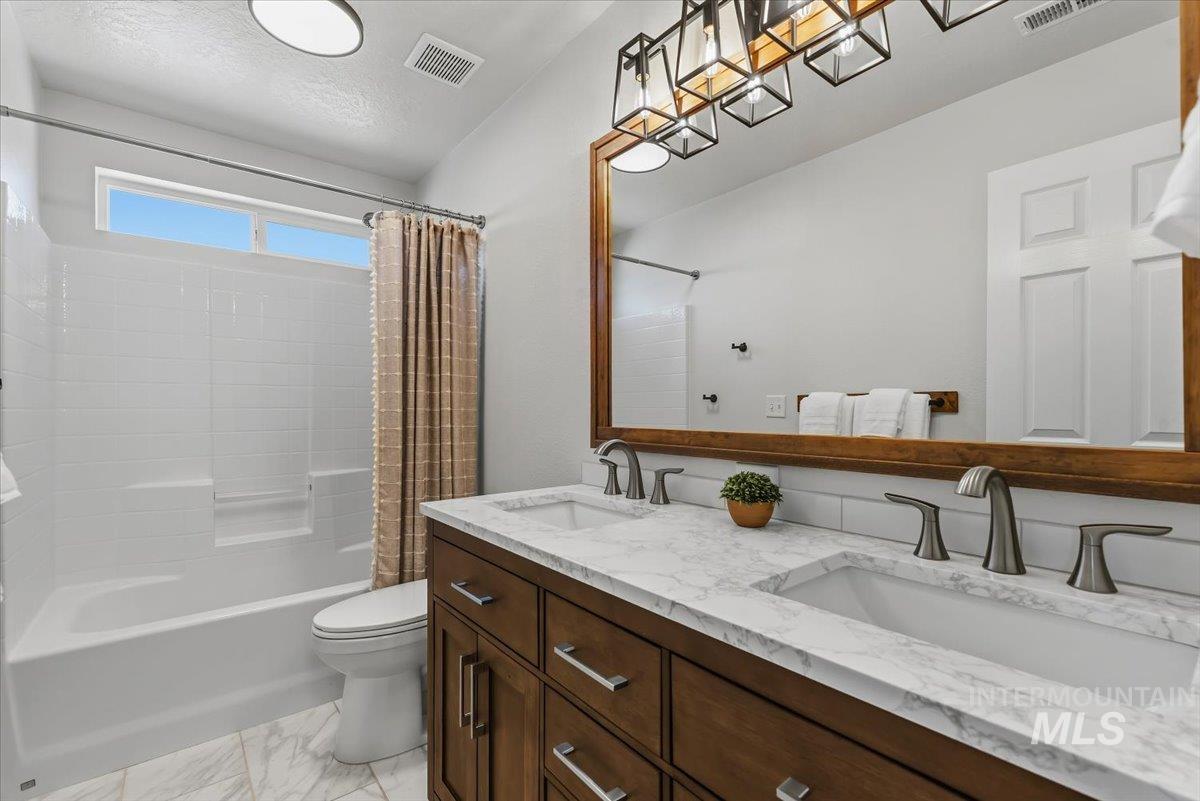 12310 West Hidden Point Drive Star, ID 83669 - Photo 24 of 48 Dual vanity with undermount sinks, stone-finish countertop, and brushed nickel fixtures