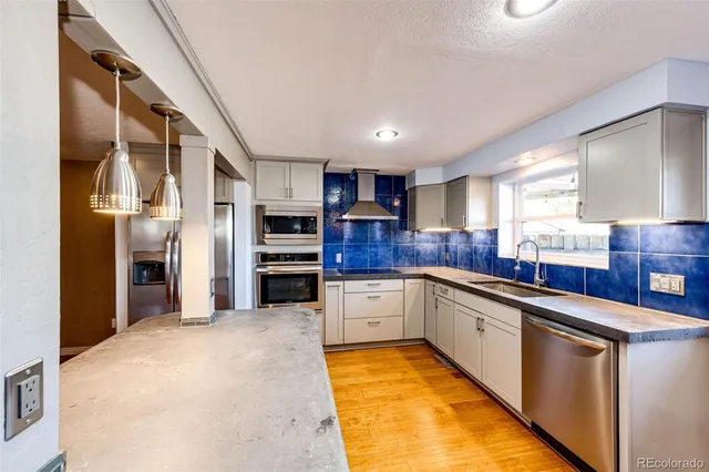 a large kitchen with stainless steel appliances lots of counter space and a sink