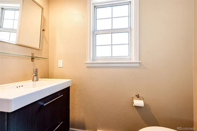 a bathroom with a sink a toilet and a window