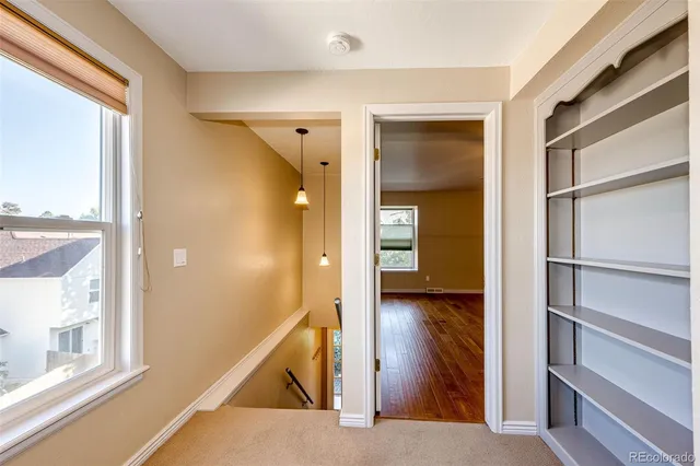 a view of a hallway with wooden floor and entryway