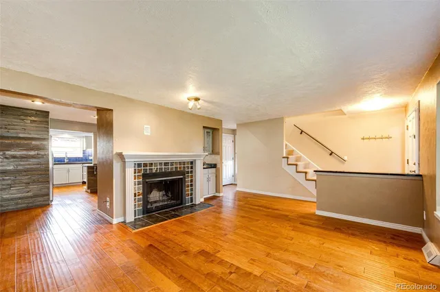a view of a livingroom with wooden floor fireplace and window