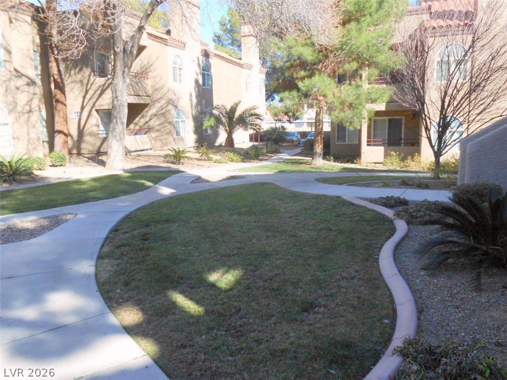 9325 West Desert Inn Road, Unit 132 Las Vegas, NV 89117 - Photo 26 of 36 Concrete walkways wind through well-maintained green spaces, connecting inviting apartment structures.