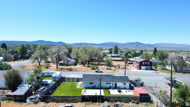 340 West 100 N Street Beaver, UT 84713 - Photo 36 of 37 Single-story residence featuring a dark shingle roof, a fenced backyard with a manicured lawn, and a concrete patio space