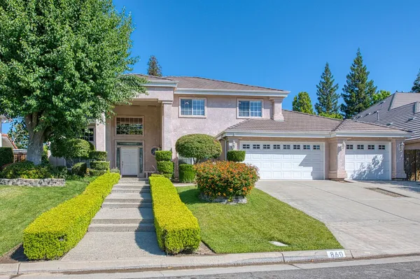 a front view of a house with a yard and potted plants