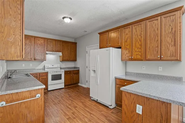 a kitchen with stainless steel appliances granite countertop a sink stove and cabinets