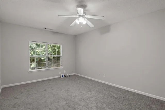 a view of an empty room with a ceiling fan