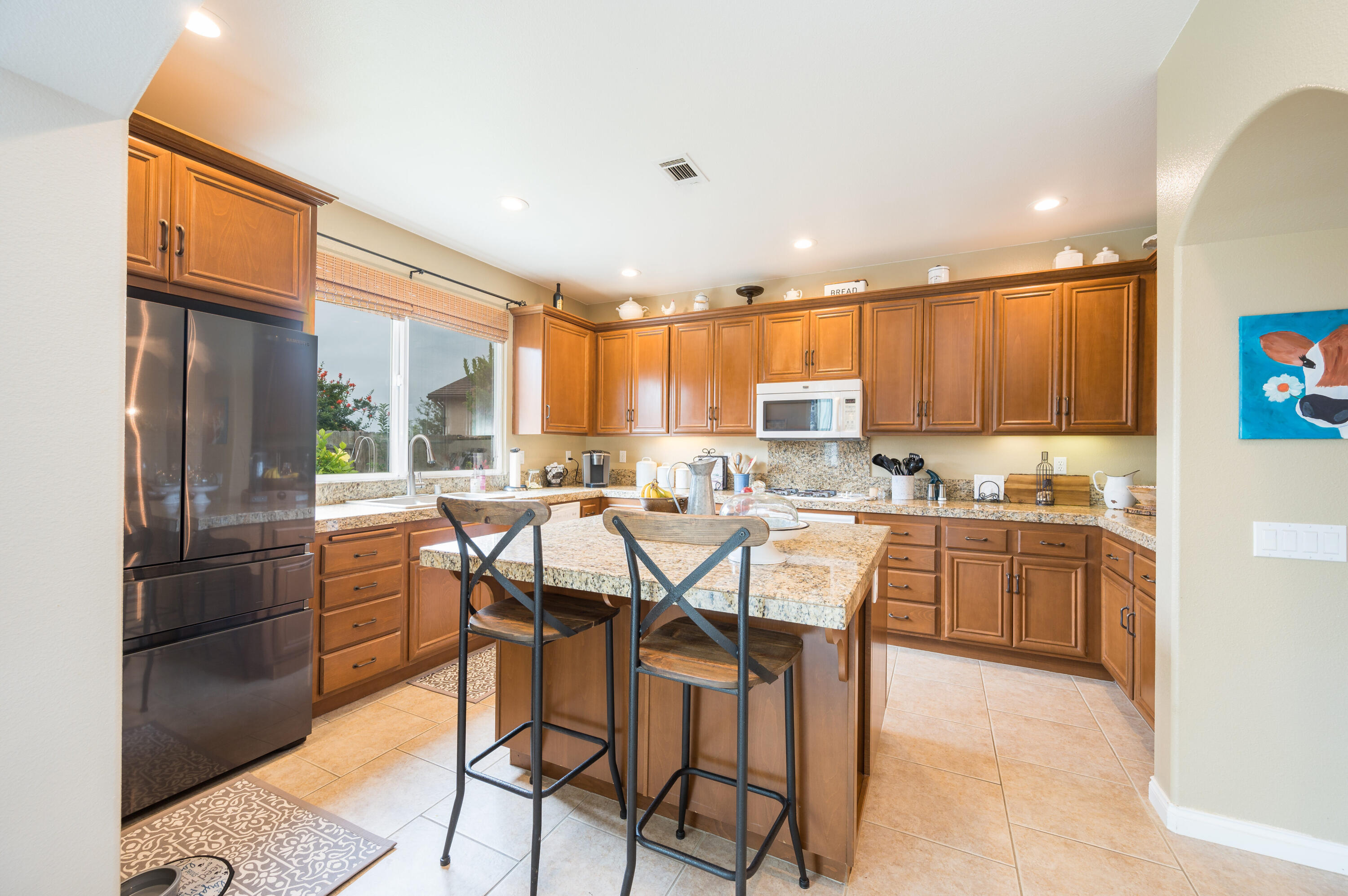 529 Palomar Circle Lompoc, CA 93436 - Photo 14 of 42 a kitchen with a refrigerator a sink dishwasher with a dining table and chairs