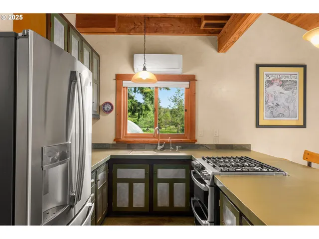 a kitchen with stainless steel appliances a stove a refrigerator and a window