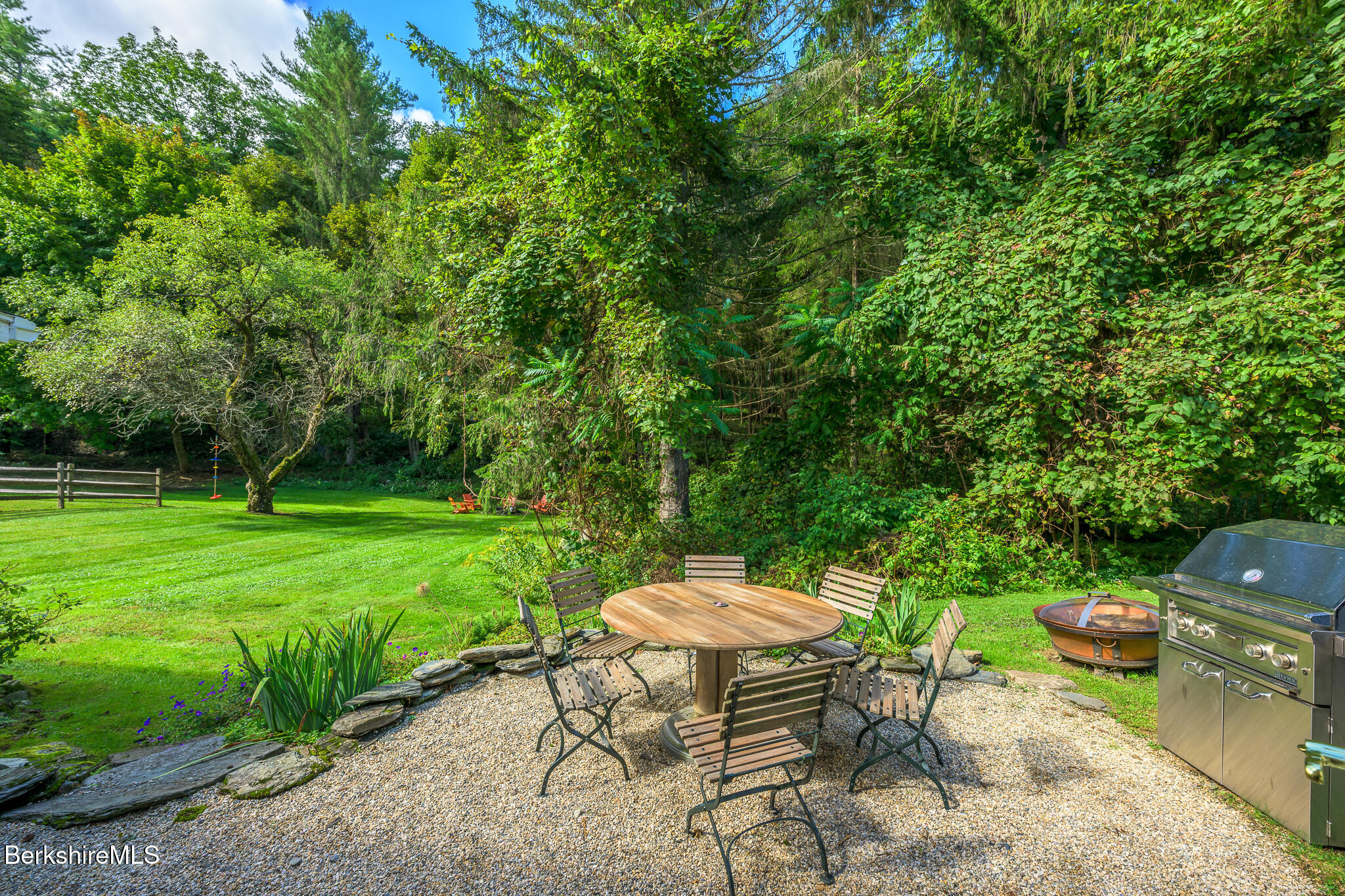 270 Hillsdale Road Egremont, MA 01230 - Photo 33 of 39 a view of a backyard with table and chairs with a barbeque grill and plants