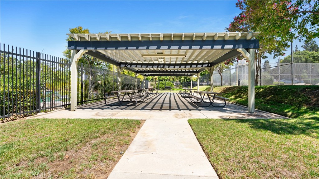 1598 Border Avenue, Unit H Corona, CA 92882 - Photo 23 of 37 a view of swimming pool with lawn chairs and wooden fence