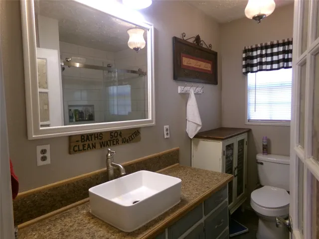 a bathroom with a sink toilet and mirror