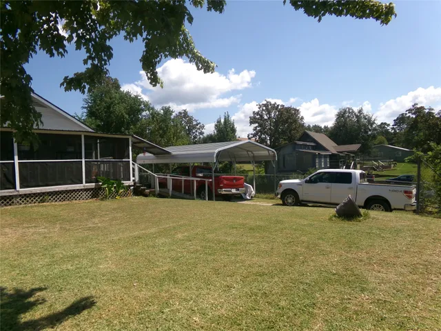 a view of a house with backyard space and trees