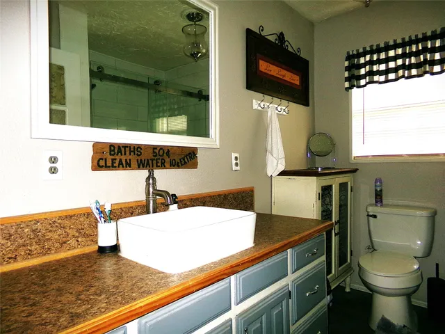 a bathroom with a sink a toilet and a mirror