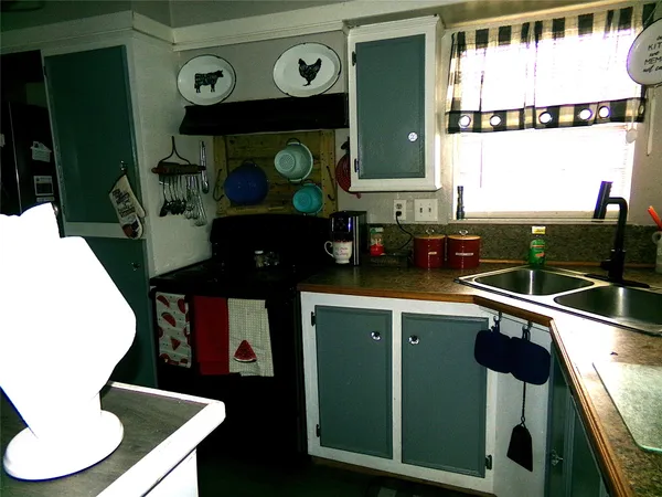a kitchen with a sink a stove and chairs