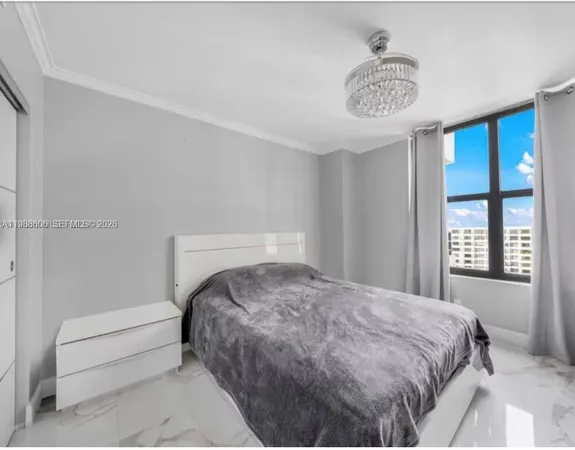 a bedroom with a bed and a chandelier