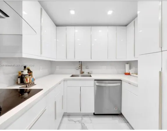 a kitchen with stainless steel appliances granite countertop a sink and dishwasher a stove top oven with white cabinets